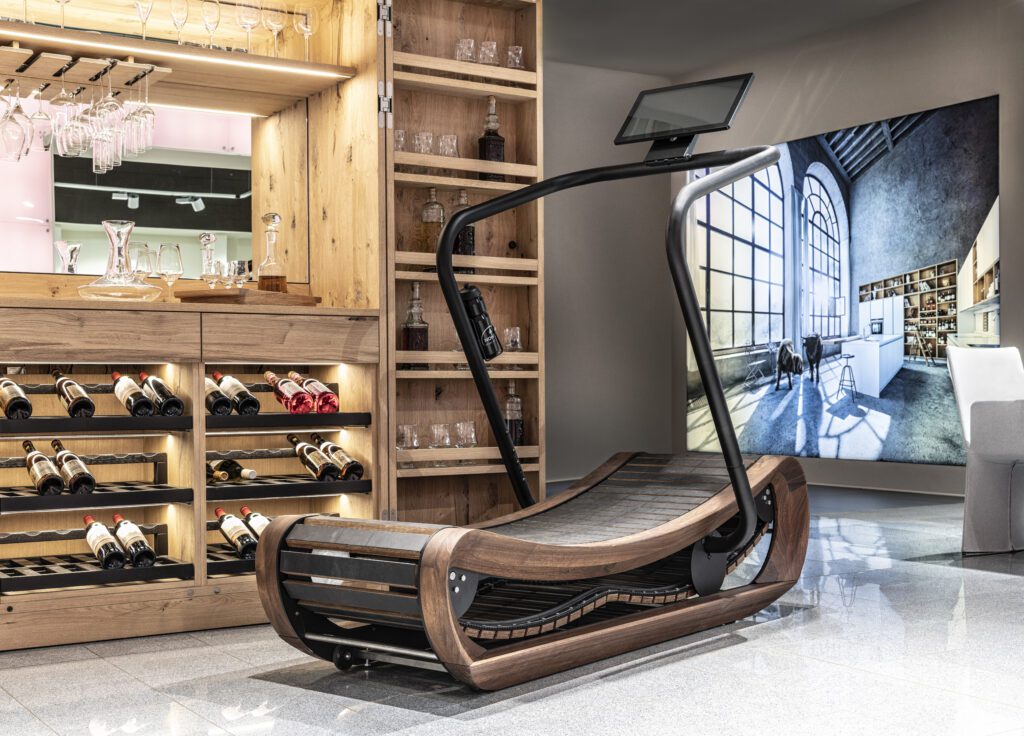 A modern wooden treadmill with a sleek curved design in a cozy room.